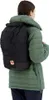 A person wearing a green jacket and a black backpack. Produktbild-Vorschau