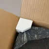 Inside of a cardboard box, showing a product wrapped in plastic and a white foam insert. Anteprima dell’immagine prodotto