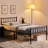 A bedroom scene with a metal bed frame, bedding, and a floor lamp. Podgląd zdjęcia produktu
