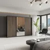 A modern bedroom with a large sliding door wardrobe, a black armchair, and a coffee table. Produktbild-Vorschau