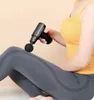 A person is using a massage gun on their leg. Produktbild-Vorschau
