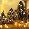 Three miniature artificial Christmas trees decorated with string lights. Náhled obrázku produktu