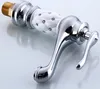 A close-up studio shot of a single faucet handle with a white, diamond-patterned grip adorned with small rhinestones, set against a reflective white and light gray background. Podgląd zdjęcia produktu