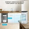 A portable air cooler is shown in a kitchen setting, next to kitchen cabinets and on a wooden table. Produktbild-Vorschau