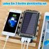 A solar power bank is shown charging multiple devices, including a smartphone, with a promotional text overlay. Produktbild-Vorschau