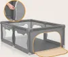 A gray playpen with mesh sides and an orange mat on the floor, shown with a close-up inset of a hand zipping up a side panel. Anteprima dell’immagine prodotto