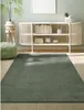 A living room scene with a rug, a cabinet, a plant, and a pouf. Produktbild-Vorschau