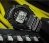 A black Casio digital watch is shown in a close-up shot, resting on a black surface with yellow cables in the background. Produktbild-Vorschau