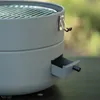A close-up of a portable grill with a small drawer pulled out. Produktbild-Vorschau