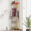 A gold metal corner coat rack with shelves, displaying clothing, a hat, a bag, and shoes. Podgląd zdjęcia produktu