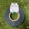 A roll of dark green garden tape is shown on a background of artificial grass. Voir les images du produit