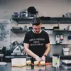 A man in a kitchen preparing food. Anteprima dell’immagine prodotto
