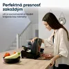 A woman is using a food slicer in a kitchen setting, with vegetables and sliced meat visible. Náhľad obrázku produktu