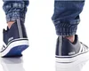 Close-up of a person's feet wearing dark blue Adidas sneakers and denim jeans. Náhľad obrázku produktu