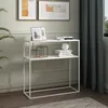 A white console table with two shelves, decorated with picture frames, books, and decorative objects, placed in a room with a plant and curtains. Náhled obrázku produktu