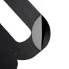 A close-up view of a black clock mechanism with a peeling layer revealing a gray surface underneath. Náhled obrázku produktu