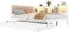 A white wooden bed with a beige upholstered headboard and a pull-out trundle bed underneath. The headboard has integrated shelving with LED lighting, displaying decorative items and a smartphone. Produktbild-Vorschau