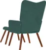 Rear view of a dark green velvet armchair with a matching ottoman and wooden legs, isolated on a white background. Náhľad obrázku produktu