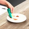 A hand is cleaning a white plate with sauce on it using a green and yellow sponge. Anteprima dell’immagine prodotto