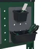 Close-up of two black storage bins attached to a pegboard on a green workbench. One bin holds a white and green trowel, and the other holds green-handled tools. Produktbild-Vorschau