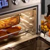 Close-up view of an air fryer oven with food inside, showing its interior and controls. Podgląd zdjęcia produktu