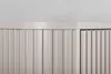 A close-up view of the top and front of a beige cabinet with vertical ribbed doors. Náhled obrázku produktu