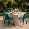 An outdoor dining table set for a meal, with chairs arranged around it. Voir les images du produit
