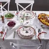 A festive Christmas table setting with plates, cutlery, food, and a candle. Anteprima dell’immagine prodotto