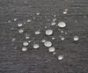Water droplets on a textured gray fabric surface. Podgląd zdjęcia produktu