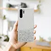 A hand holds a smartphone case with glitter. Produktbild-Vorschau