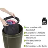 A person's hands are placing a black laundry bag with clothes into a dark brown hamper. Produktbild-Vorschau