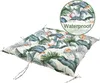 A close-up, angled view of a square cushion with a tropical leaf pattern, set against a white background. A circular inset in the top right corner shows water droplets on the cushion's fabric and the word 'Waterproof'. Produktbild-Vorschau