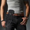 A man wearing a grey t-shirt and jeans, with a black tactical belt pouch attached to his belt. Produktbild-Vorschau