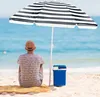 A person sits on a beach under a striped umbrella, looking out at the ocean. Voir les images du produit