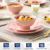 A table setting with pink marble-patterned dinnerware, including plates and bowls filled with food, and gold cutlery. Produktbild-Vorschau