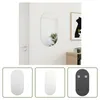 A mirror hanging on a white wall next to a door and a cabinet with a framed picture. Podgląd zdjęcia produktu