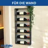 A black metal wine rack mounted on a wall, holding six bottles of red wine. A green plant hangs over the top right of the rack. Náhľad obrázku produktu
