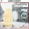 A fluffy beige seat cover in a snowy forest setting. Produktbild-Vorschau