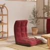 A red floor chair is placed on a rug in a room with a plant and a shelf. Produktbild-Vorschau
