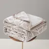 Two folded blankets stacked on a small wooden table. Podgląd zdjęcia produktu