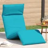 A turquoise chaise lounge chair is set up on a patio next to a wooden fence and a small table with a pitcher of lemonade. Anteprima dell’immagine prodotto
