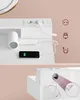 A close-up view of a white vanity desk with a built-in power strip and a smartphone charging, accompanied by a separate detailed view of cable management within the desk structure. Produktbild-Vorschau