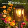 A solar garden light is shown in a garden setting with flowers and rain. Produktbild-Vorschau