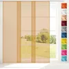 A transparent panel curtain in beige is shown hanging in front of a window, with a selection of other color swatches displayed to the right. Voir les images du produit
