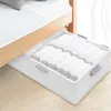 A white under-bed storage box filled with neatly folded white towels, placed under a bed. Voir les images du produit