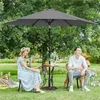 A couple and a dog enjoying a picnic under a large gray umbrella in a park. Produktbild-Vorschau