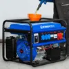 A person is pouring fuel into a blue generator. Produktbild-Vorschau