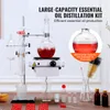 A laboratory setup for distilling essential oils, with various glass components, a heating plate, and small bottles. Náhled obrázku produktu