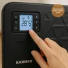 A close-up of a hand interacting with the control panel of a black KAMINER electric heater. Náhľad obrázku produktu