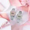 Two Casio digital watches are displayed on a white surface with pink fabric accents and a white gift box. Produktbild-Vorschau